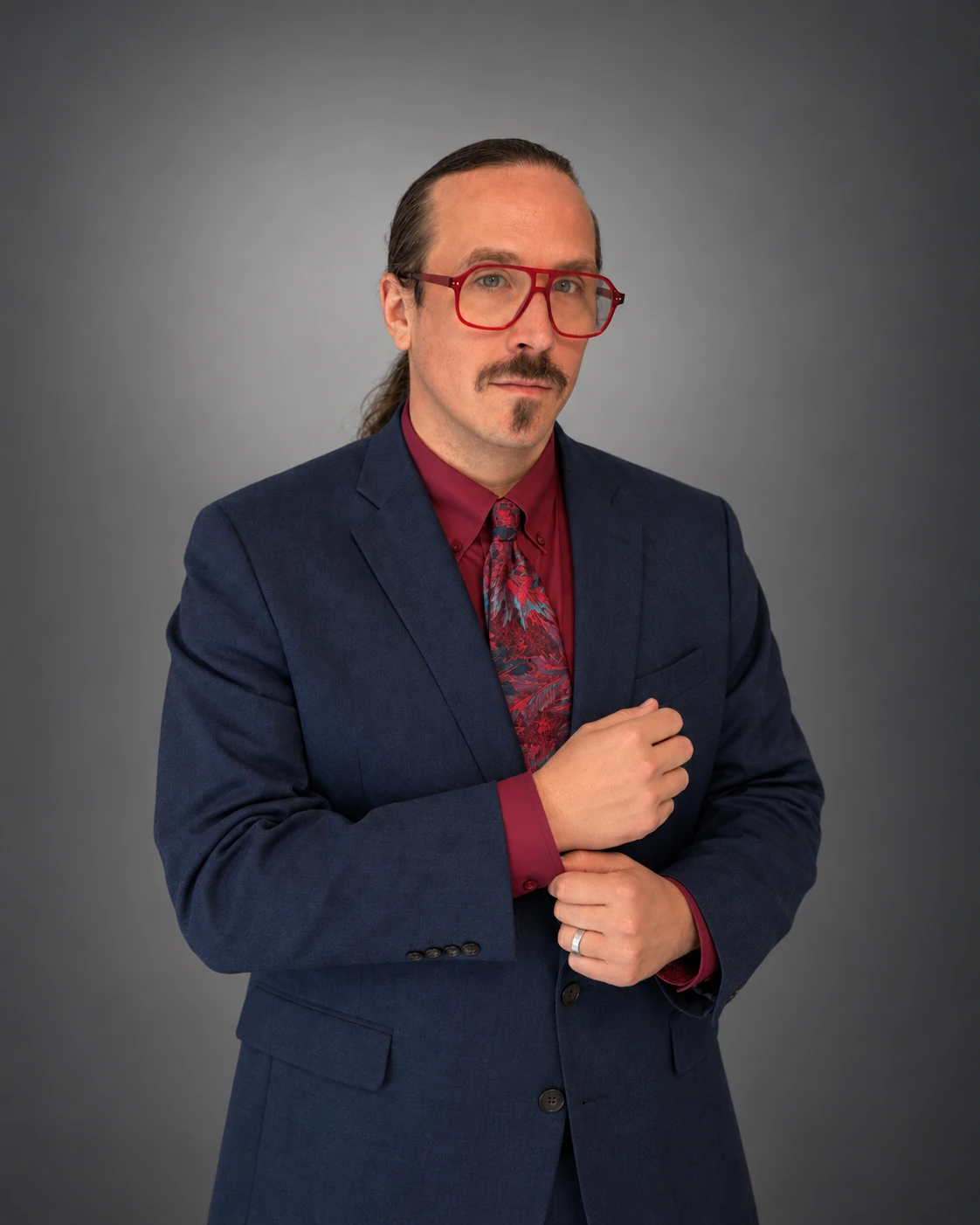 Chris Uehlein wearing red glasses and a navy suit